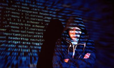 Cyber attack with unrecognizable hooded hacker using virtual reality, digital glitch effect