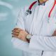 Young handsome physician in a medical robe with stethoscope