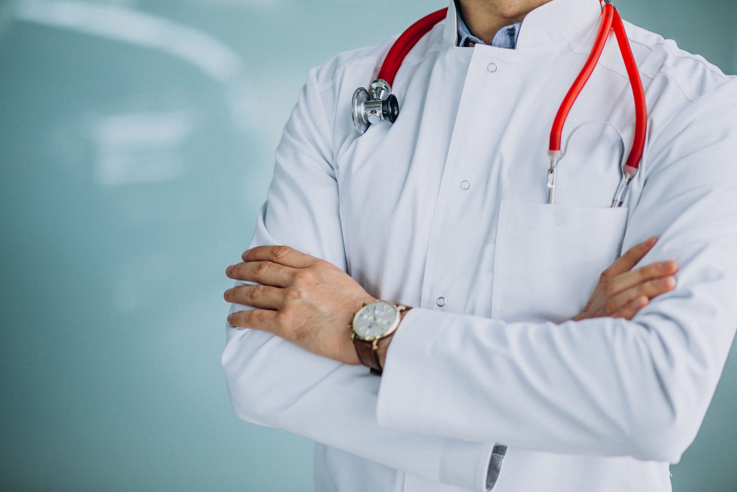 Young handsome physician in a medical robe with stethoscope